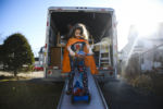 DOVER, NH - 11/31/2019 Evan Lupien rides his scooter down the ramp of the moving truck while friend's and family help the Lupiens move into their new apartment. The family has been homeless since July, with most of the children's toys stored away in storage, and Evan was excited to be reunited with his scooter.