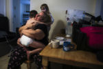 DOVER, NH - 12/01/2019 Dylan Lupien wraps himself around his mom Mariah LeMieux-Lupien in a tight hug on their first morning at their new apartment. The family has been living in the apartment for a little over a week. The floors are carpeted and the kids have bunk beds. Mariah and Patrick are trying to get used to the larger paychecks, the locks on the doors, the feeling that their family might be safe for a while. Sometimes, when they are in the van for too long, Evan thinks theyÕre moving again. ÒItÕs still very twilight. It still doesnÕt feel real,Ó Mariah says.