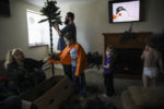 DOVER, NH - 12/07/2019 Frosty the Snowman plays in the background while Mariah LeMieux-Lupien, left, hands a branch to her son Evan as they set up their Christmas tree in the living room. With boxes still left to unpack, the Lupien family is slowly settling into their new apartment. ÒBetween the better paying job and learning how to manage what we have, has left us with a new and quite strange feeling of not needing to panic," says Mariah. "The sadness and shame from not being able to provide as well as we have wanted to, that well worn path in my brain, all that energy can be rerouted to somewhere else.Ó