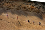 Beachgoers make the steep climb up a towering sand dune cliff from White Crest Beach in Wellfleet to the parking lot above. White Crest is one of the steepest walks to any beach on the Cape Cod National Seashore. Steps that were built years ago have long vanished in the erosion. The shoreline keeps getting chewed away by powerful storms.