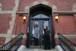 A couple stands on their front porch and raise their fists in support of passing protestors demonstrating against racial inequality following the death in Minneapolis police custody of George Floyd, in Boston, Massachusetts, June 4, 2020.