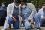 Nurses Sasha Dubois (L) and Farah Fevrin kneel during 8 minutes and 46 seconds of silence at a vigil against racial inequality, following the death in Minneapolis police custody of George Floyd, at Brigham and Women’s Hospital, where many coronavirus disease (COVID-19) patients have been treated, in Boston, Massachusetts, June 5, 2020.