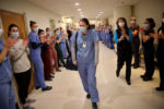 Boston,MA - 4/16/2020: Lauren Detmer, a front-line worker at Massachusetts General Hospital, returned to a heroÕs welcome after being isolated at home for three weeks with COVID-19. Forty of her colleagues in scrubs and blue masks lined a hospital hallway at 7:30 a.m. and, when she rounded the corner, erupted into applause.