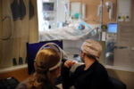 Worcester, MA - 12/10/2020: Respiratory therapist Barbara Silva (left) and registered nurse Mary Davis observed a patient through a window in the COVID Intensive Care Unit at UMass Memorial Medical Center in Worcester., MA.
In December, UMass MemorialÕs two Worcester campuses were treating 44 critically ill COVID patients Ñ more than any other hospital in Massachusetts, according to state data. That remains below the last peak in the spring, when UMass Memorial rapidly opened eight new ICUs and retrained staff to treat the flood of sick patients.
