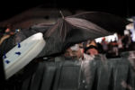 A protester takes cover during clashes outside the Kenosha County Courthouse late Tuesday, Aug. 25, 2020, in Kenosha, Wis. Protests continue following the police shooting of Jacob Blake two days earlier.
