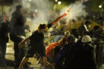A protester launches a projectile toward police during clashes outside the Kenosha County Courthouse, late Tuesday, Aug. 25, 2020, in Kenosha, Wis. Protests continue following the police shooting of Jacob Blake two days earlier.