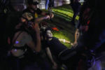 Gaige Grosskreutz, top, tends to an injured protester during clashes with police outside the Kenosha County Courthouse in Kenosha, Wis., Tuesday, Aug. 25, 2020. Within minutes, Grosskreutz would be the one bleeding on the ground. He survived a triple shooting. Grosskreutz was among three people shot on the third night of protests after Kenosha police shot a Black man, Jacob Blake, seven times in the back.