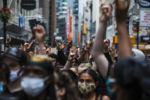 BOSTON - 6/10/2020: People lift up their hands to signal that they can hear the speaker during a march organized by the Coalition of Black Youth. The demonstrators marched from Nubian Square to City Hall to urge Boston City Council to reallocate Boston police funding to youth jobs programs like SuccessLink, violence prevention, and to hire additional mental health counselors in Boston Public Schools.