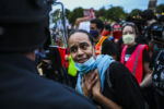 BOSTON - 6/2/2020: A woman tries to reason with the Boston Police to as she participates in a demonstration outside of the Forest Hills T Station. The rally and vigil took place on Blue Ave by Franklin Park to honor George Floyd, Breonna Taylor, Ahmaud Arbery and local fallen people. The demonstration was organized by Black Lives Matter Boston and Violence in Boston.