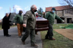 Everett, MA--12/10/20-- Alan Giangregorio (L) helps to carry a casket to the grave at Woodlawn Cemetery. On the heels of the deadliest year in US history Giangregorio arrives each morning before the sun, a cup of gas station coffee in his hand, and quietly punches his time card. He carries out this grim work without complaint, or the expectation of notice.