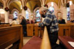 Winthrop, MA--12/12/20-- Alan Giangregorio prays during mass at St John the Evangelist Church on his only day off. Even at church there is no sidestepping work or the virus, when he arrives he chats with a woman who lost her husband to COVID. The family in the pew behind him just buried their father at Woodlawn and they thank Alan for his attention to detail in cleaning off the stone for his grave. For Alan there is one act of kindness that stands above the rest, ÒWhen you take care of someoneÕs dead,Ó he says, Òthey never forget it.Ó
