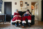 (Synopsis: Dennis Mann, 74, and a Rhode Island native, has been making public appearances as Santa Claus across New England for the past 20 years, but due to COVID-19 in 2020, this years Christmas season has been very different for him. Unlike the busy schedule that Santa Dennis is typically used to with various events like mall appearances, parties, at-home visits, and parades, this year he had to lay low with all public appearances for the holiday season. “I’ll really miss the smiles of the kids and the families this year.” Santa had said when asked what he will miss the most this Christmas. “The personal connection you have with each kid is for sure something that will be missed this year for everyone.” However, the pandemic did not stop him from bringing the spirit of Christmas to communities in Rhode Island.
“Helping is something we can still do, and it’s especially important for us this year,” Dennis said. Every year Santa Dennis and his partner Sheila, 75, donate $11,000 worth of toys and food to places like Operation Stand Down of Rhode Island. This non-profit organization provides services for Rhode Islands’ homeless, at-risk veterans. They also donate to Crossroads Rhode Island and Crossroads Family Shelter, which specialize in housing services to those experiencing homelessness. “My kids will not go without toys this year.” Mrs.Claus Sheila said when packing toys, backpacks, and food to donate.
“I’m most worried because I’m immunocompromised...” Santa said as he explained why he was not doing any in-person appearances this year, “but I’ll still be doing a few video calls to some family.” Although Santa and Mrs.Claus were able to bring the spirit of Christmas to Rhode Island this time around without public appearances, they are both hoping that next year will be back to the usual busy routine when the holidays swing around.)
Dennis and Sheila sit together in their living room while talking about the various memories they’ve shared over the years during the holiday season and the moments they will be missing in 2020 due to COVID-19.