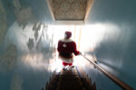 Dennis walks down a set of steps in his old-mill home that he has built upon over the decades.