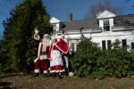 Sheila and Dennis wave on a family driving passed their home.