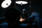From 2015-2016 alone Venezuela saw a 65% increase in maternal mortality according to Amnesty International. Then again in 2018 Venezuela saw another 65% increase in maternal mortality over the previous year according to a report from the University of Miami. The main causes, a lack of medicine and a lack of doctors. Dr. Luisangela Correa is an Emergency General Surgeon that supports Ob/Gyn in the Concepción Palacios Maternity Hospital in Caracas, Venezuela. For 19 years she has been working in the ob/gyn public hospital sector of Caracas. The public hospital sector of Caracas used to be reliable and dependable, a high quality system. Dr. Correa spends her days fighting for woman to have a place to give birth and receive gynecological care. In the last year alone Dr. Correa has seen her number of colleagues drop to less than half. Many have left the country due to the ongoing political crisis. What was once 6 surgeons is now 2. She is currently working without pay. She tells me, “If I don’t do this job, no one will. Here, there is no one left.”
Dr. Correa prepares to perform a partial hysterectomy. It took her 8 days of fighting the system to be able to perform this emergency surgery due to no sterile supplies and no surgical team. There is no functioning pathology in the hospital, so the patient will be given their uterus and tumor to find a functioning lab that can analyze it.
