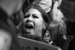 A demonstrator at a protest against police brutality places herself in between a police officer and another protester while yelling "Don't touch him" outside of the Boston Police District 4 Station on May 29, 2020.