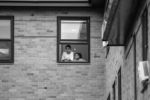 Children watch a Black Lives Matter protest at the Boston Police District 4 Station from their apartment window on May 29, 2020.