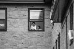Children watch a Black Lives Matter protest at the Boston Police District 4 Station from their apartment window on May 29, 2020.