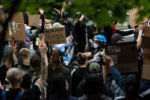 A police officer rides his motorcycle through a group of Black Lives Matter supporters at a protest in Franklin Park on June 2, 2020.