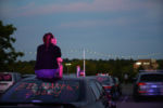 An Ed Markey supporter sits on top of her car at the "Sticking with Ed" Roxbury car rally on the night before the Senate Primary.