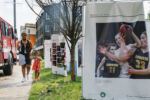 A woman and child walk past the 6-foot photo cubes during the installation of the Boston Press Photographers Association's 2020 Pictures of the Year exhibition in Justice Edward O. Gourdin Veterans Memorial Park in Boston, Massachusetts, on Mon., June 7, 2021. The ten 6-foot cubes featuring Pictures of the Year winning images had been displayed in Copley Square for the previous two weeks and will now be on view in Nubian Square for the next two weeks. The exhibition was made in partnership with GBH and Photoville with graphic design by Gene Yoon.