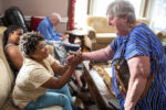 Sindy Micourt high-fives Thrive resident Sharon at the Thrive Support and Advocacy center in Marlborough, MA on August 7, 2024.
