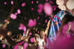 Confetti falls as Rosmy Dorcelus (center in white shirt) and Darlene Noriston (obscured in back, wearing blue shirt) learn their next child is a girl during a gender reveal in Worcester, MA on August 25, 2024.